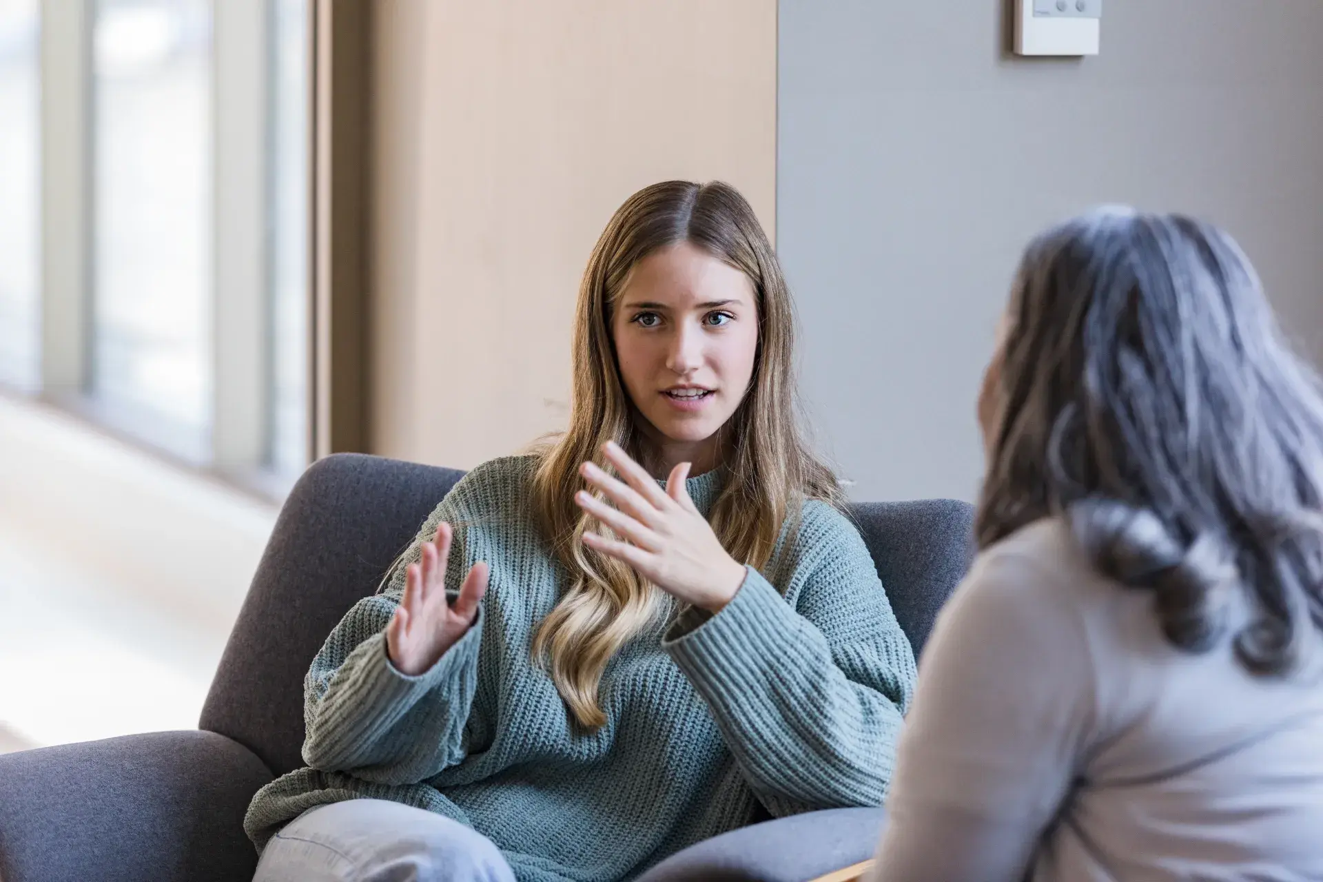 Young woman talking with a counsellor in a bright, quiet room